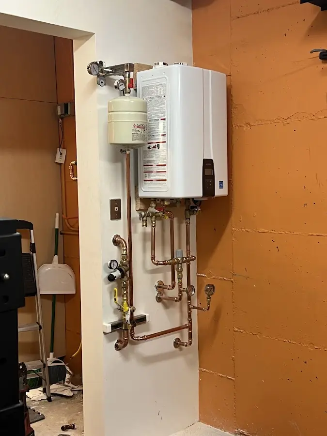 Plumbing technician inspecting water heater connections in Speedway